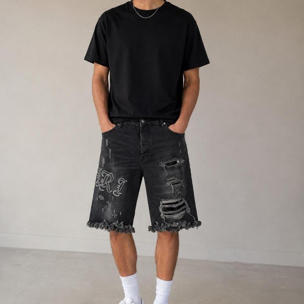 Amiri black denim shorts with white embroidered lettering and distressed details